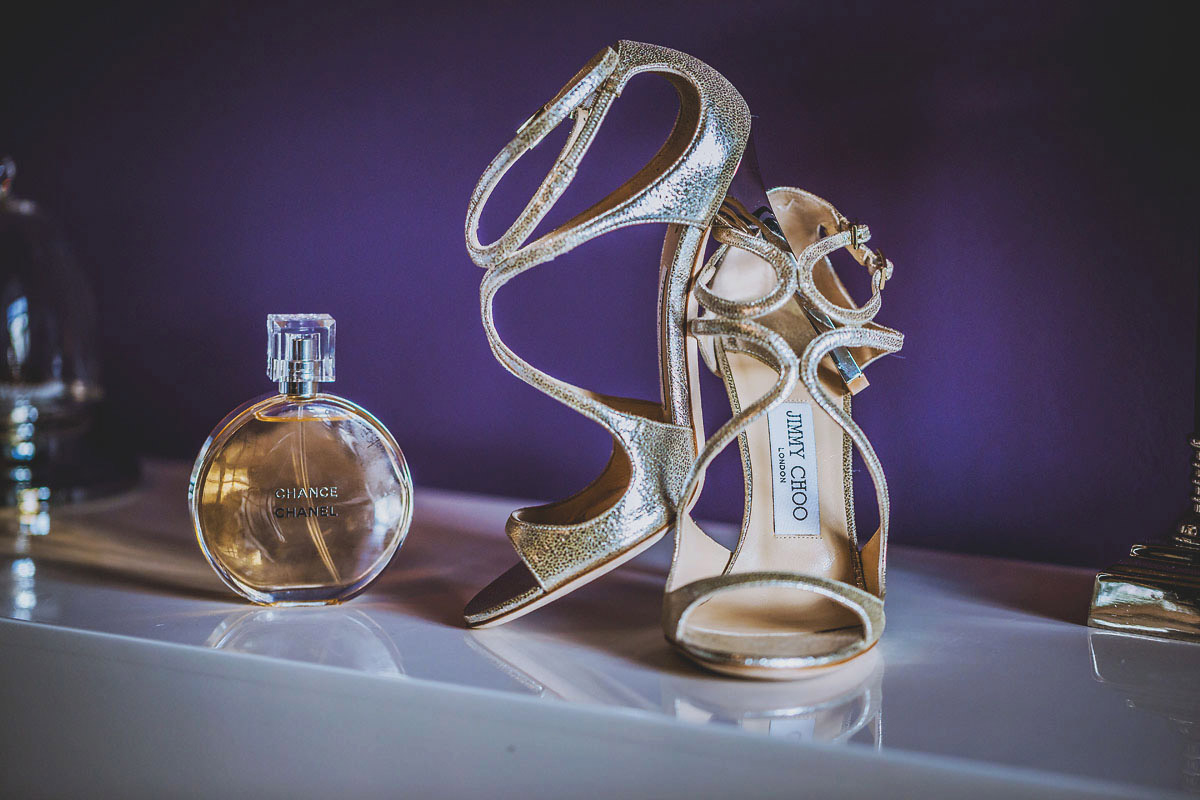 Schuhe der Braut von Jimmy Choo und Parfum liebevoll arrangiert für ein Hochzeitsfoto vom Hochzeitsfotograf Brandenburg © www.henninghattendorf.de