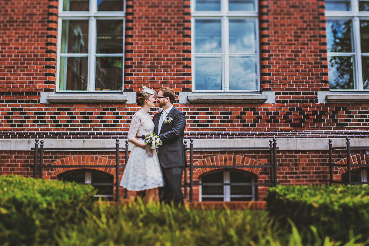 Brautpaar an der Fassade vom Standesamt Neukölln beim Fotoshooting Hochzeitsfotograf © www.henninghattendorf.de